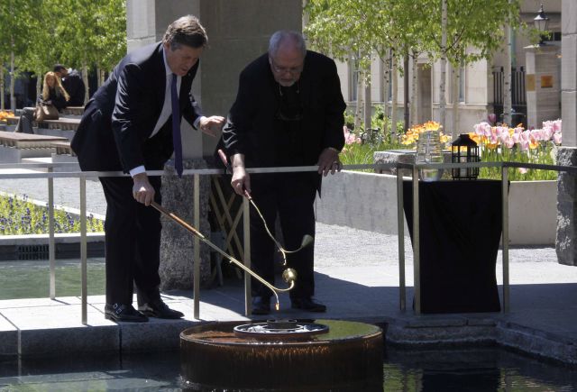 Mayor John Tory and Father Massey Lombardi light the flame of peace